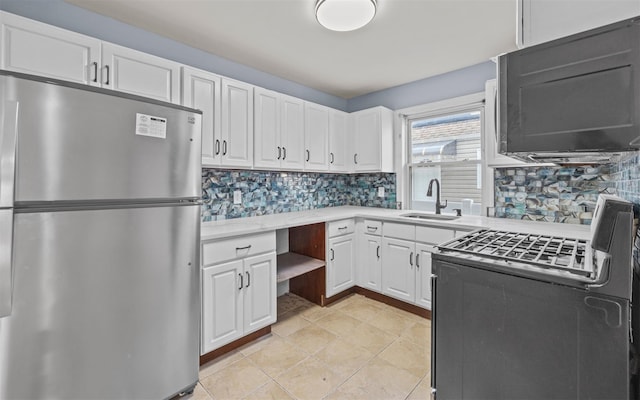 kitchen with white cabinetry, light tile patterned floors, gas range, sink, and stainless steel fridge