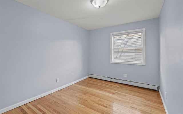 spare room with baseboard heating and light wood-type flooring