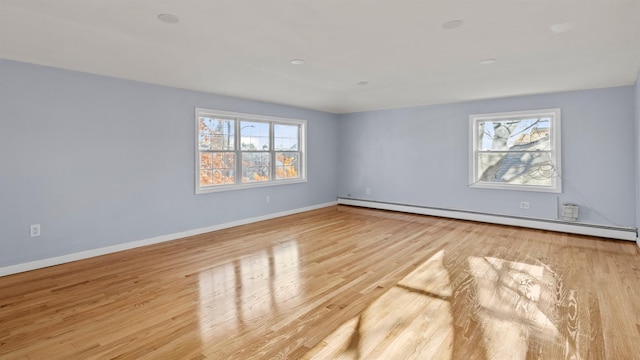 spare room featuring light wood-type flooring and a baseboard heating unit