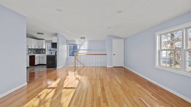 unfurnished living room featuring light hardwood / wood-style floors and lofted ceiling