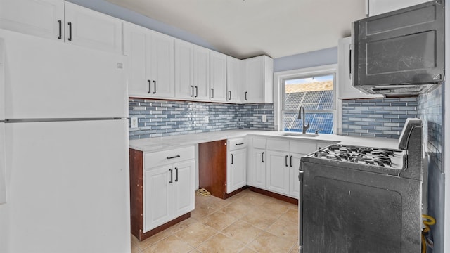 kitchen featuring white cabinets, black appliances, tasteful backsplash, sink, and light tile patterned floors