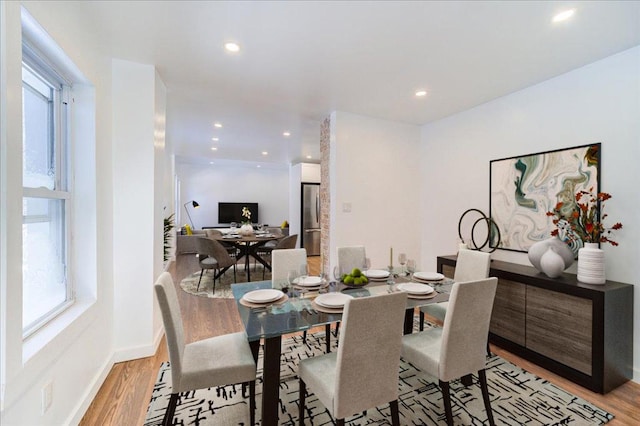 dining area with light hardwood / wood-style flooring and a healthy amount of sunlight