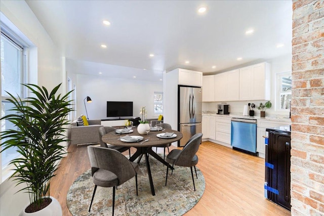 kitchen with sink, white cabinets, stainless steel appliances, and light hardwood / wood-style floors