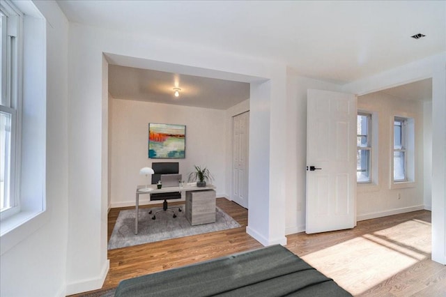 office area with hardwood / wood-style floors and a healthy amount of sunlight