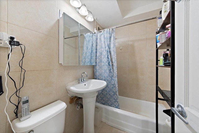 full bathroom with sink, shower / bath combination with curtain, toilet, and tile walls