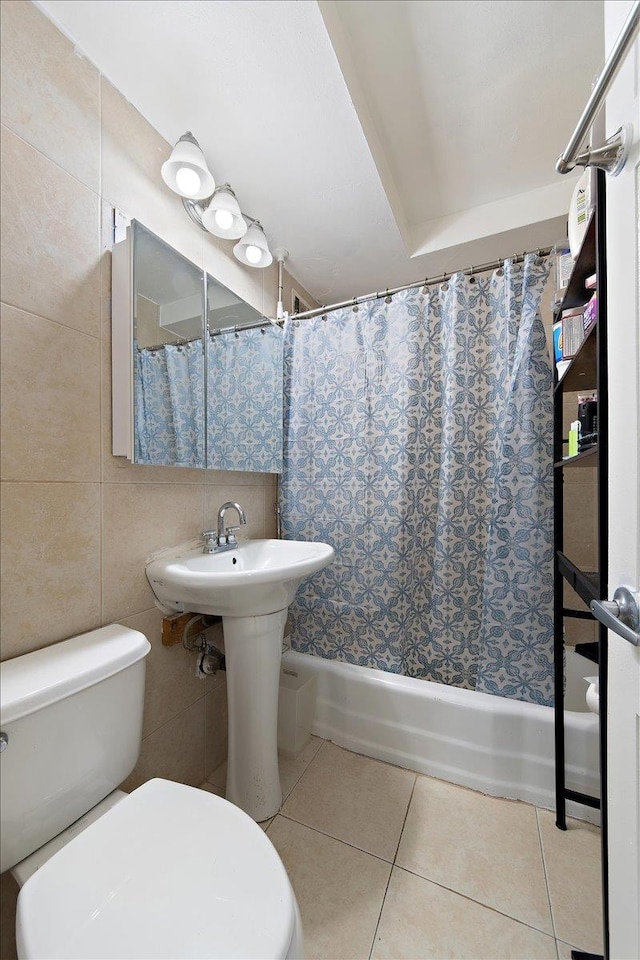 bathroom featuring tile patterned floors, shower / bath combination with curtain, tile walls, and toilet