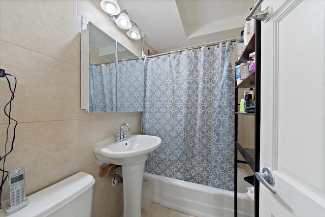 bathroom featuring tile patterned floors, toilet, tile walls, and shower / tub combo with curtain