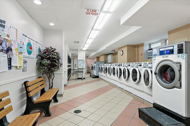 clothes washing area with washer and dryer and light tile patterned flooring