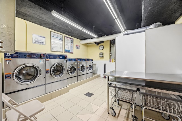 clothes washing area featuring tile patterned flooring and separate washer and dryer