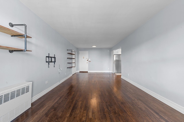 empty room featuring dark hardwood / wood-style floors and radiator