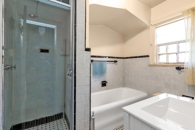 bathroom with sink, tile walls, and independent shower and bath