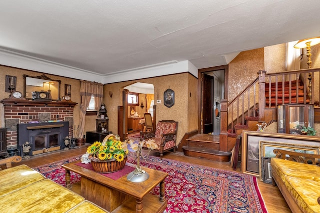 living room with hardwood / wood-style flooring, crown molding, and a textured ceiling