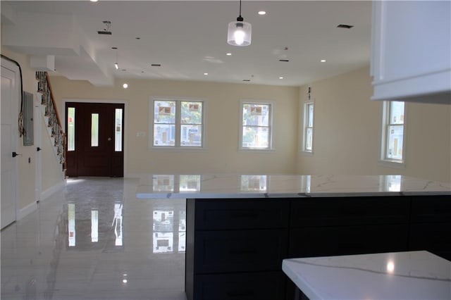 kitchen with decorative light fixtures and light stone countertops