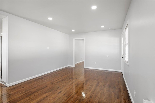 unfurnished room with dark hardwood / wood-style flooring