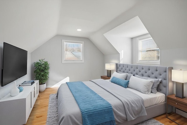 bedroom with light hardwood / wood-style floors, multiple windows, and lofted ceiling