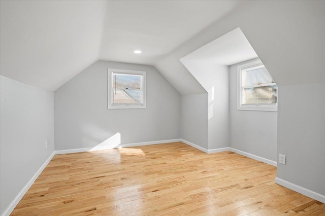 bonus room with light hardwood / wood-style floors and lofted ceiling