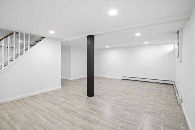 basement featuring light hardwood / wood-style flooring and baseboard heating