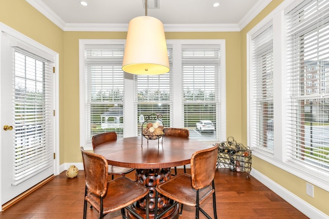 dining space with a healthy amount of sunlight, crown molding, and dark wood-type flooring