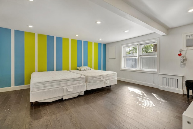 bedroom featuring beam ceiling and dark hardwood / wood-style flooring