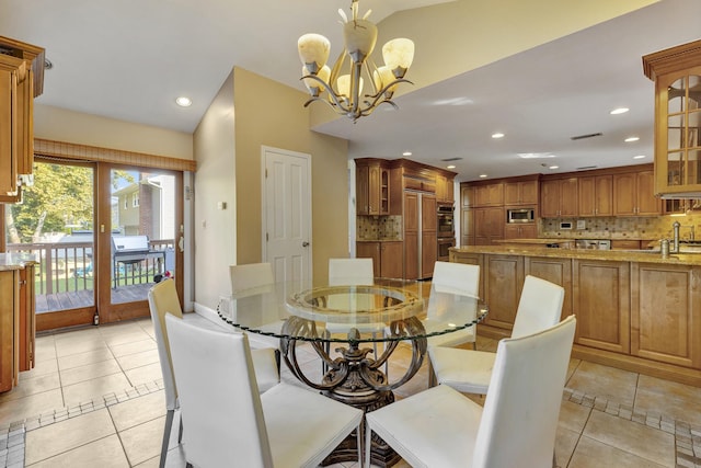 dining space featuring lofted ceiling, light tile patterned floors, and an inviting chandelier