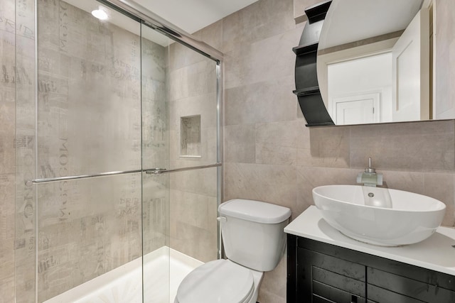 bathroom featuring walk in shower, vanity, toilet, and tile walls