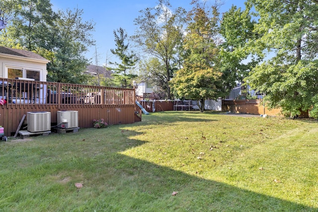 view of yard with cooling unit and a deck