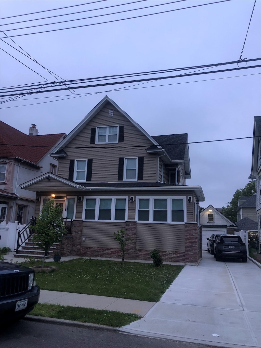 view of front facade with a garage, an outbuilding, and a front yard