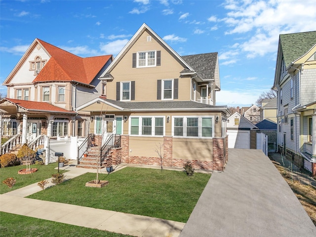 view of front of house featuring a shingled roof, brick siding, an outdoor structure, and a front lawn