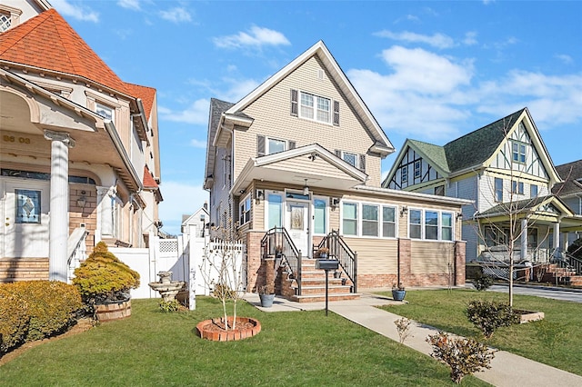 view of front facade featuring a front lawn, fence, and brick siding