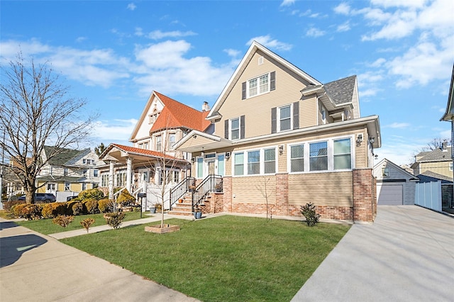 view of front of house featuring an outbuilding, brick siding, a detached garage, and a front lawn