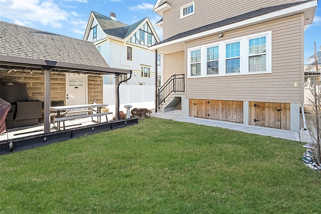 back of property featuring fence and a lawn