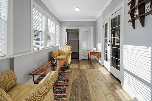 living area featuring crown molding, wood finished floors, and french doors