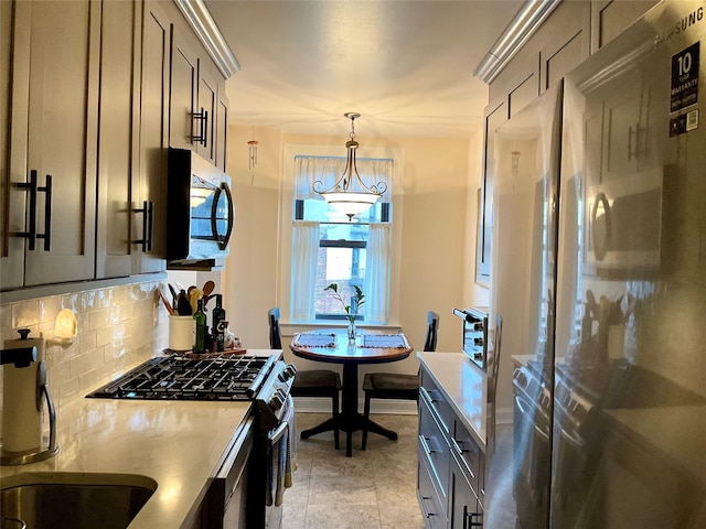 kitchen with sink, backsplash, pendant lighting, light tile patterned floors, and high end appliances