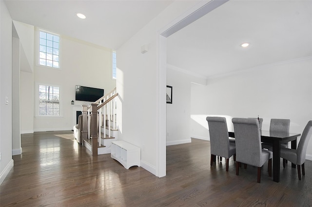 dining space with ornamental molding and dark wood-type flooring