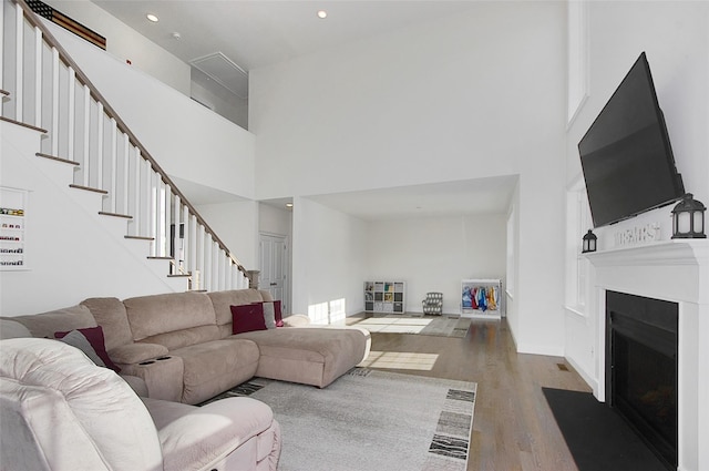 living room with a high ceiling and hardwood / wood-style flooring