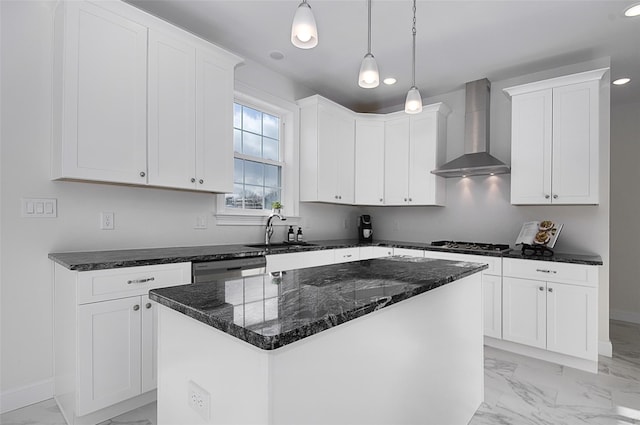 kitchen featuring wall chimney exhaust hood, a kitchen island, white cabinetry, and sink