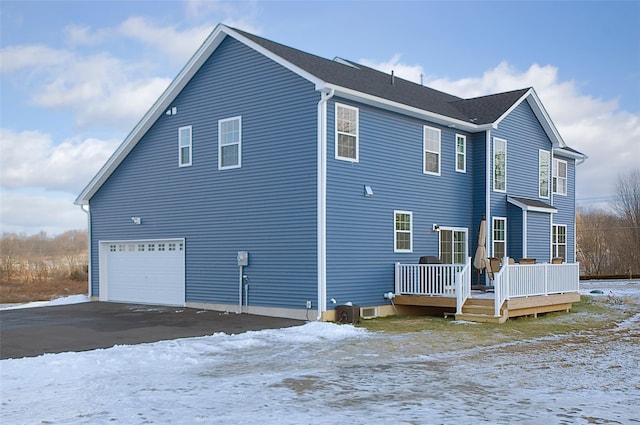 snow covered house featuring a garage