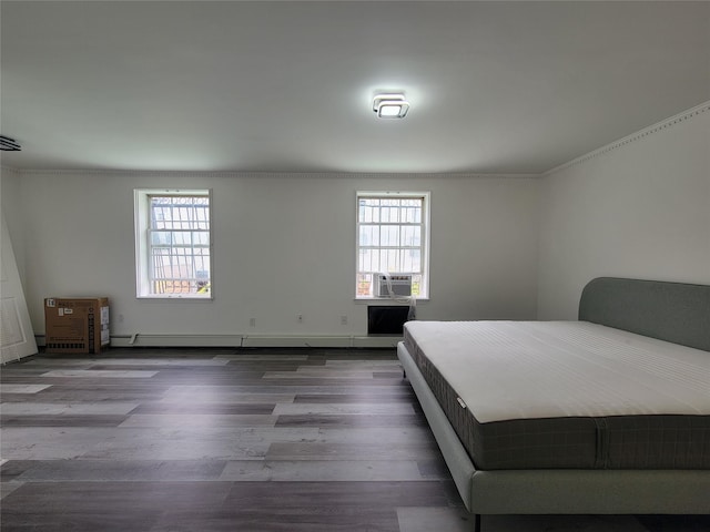 unfurnished bedroom featuring hardwood / wood-style floors and baseboard heating