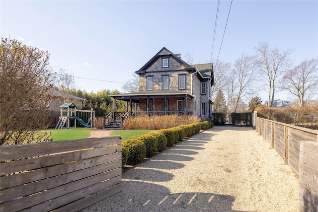 view of front of property featuring a porch and a playground