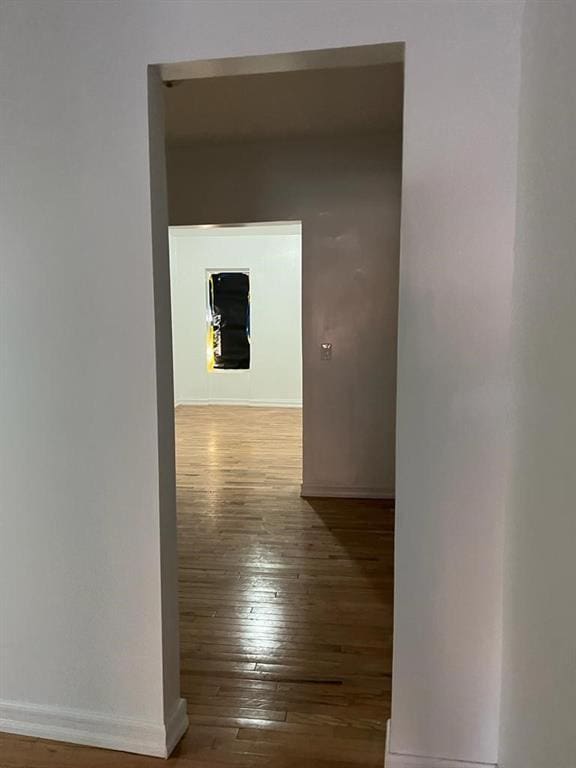 corridor with hardwood / wood-style flooring