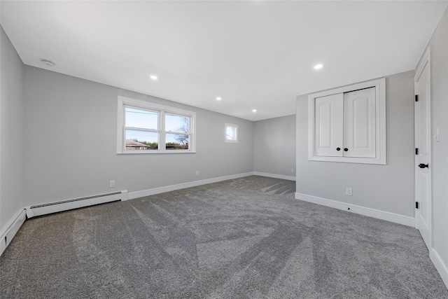 carpeted empty room with a baseboard radiator