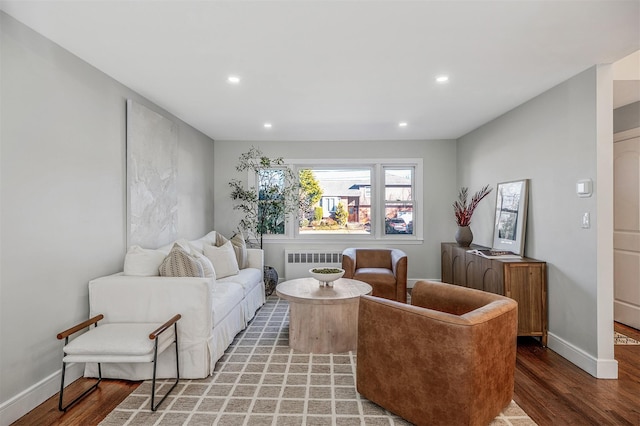 living area with radiator heating unit, baseboards, wood finished floors, and recessed lighting