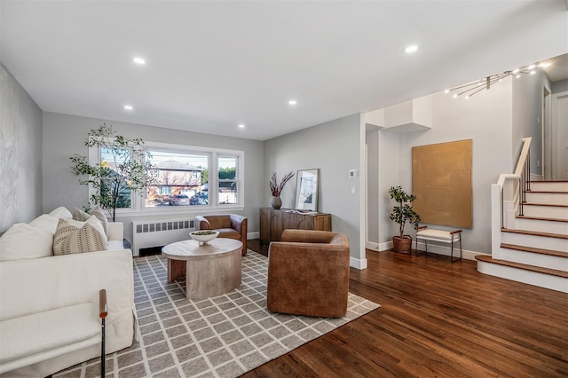 living room featuring recessed lighting, wood finished floors, baseboards, stairs, and radiator heating unit