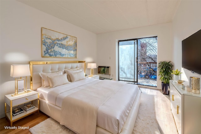 bedroom featuring hardwood / wood-style flooring and access to outside