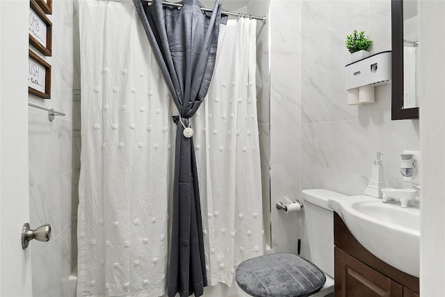 bathroom featuring vanity and tile walls