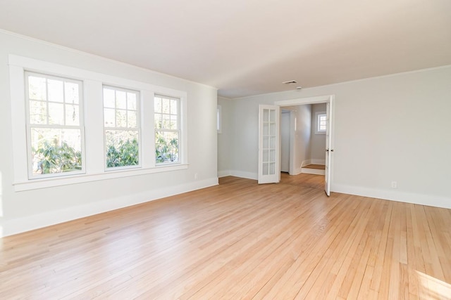 spare room with light hardwood / wood-style floors and french doors