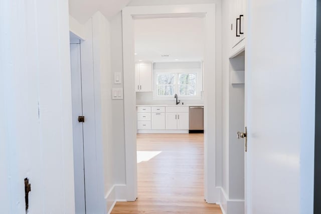 corridor featuring sink and light hardwood / wood-style flooring