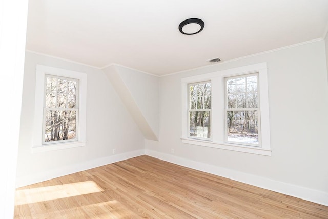 empty room featuring hardwood / wood-style flooring and crown molding