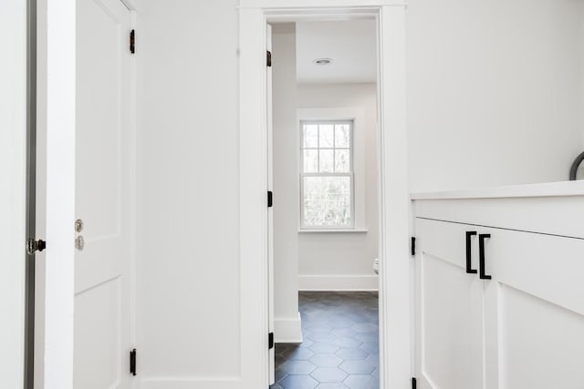 hall with dark tile patterned floors