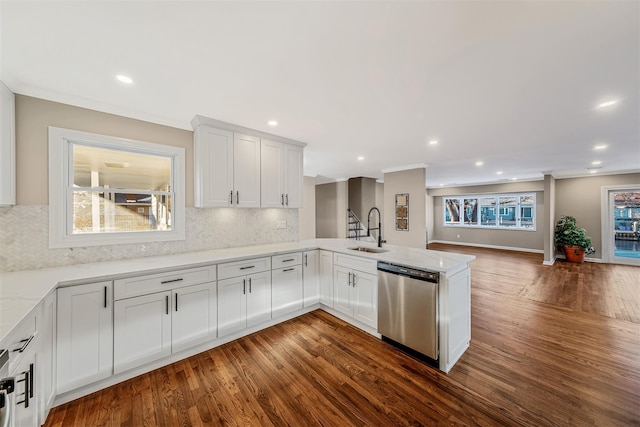 kitchen featuring kitchen peninsula, white cabinetry, stainless steel dishwasher, and plenty of natural light